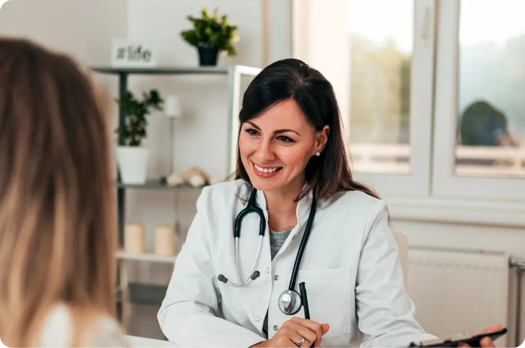 medica-sorrindo-para-paciente-em-consulta