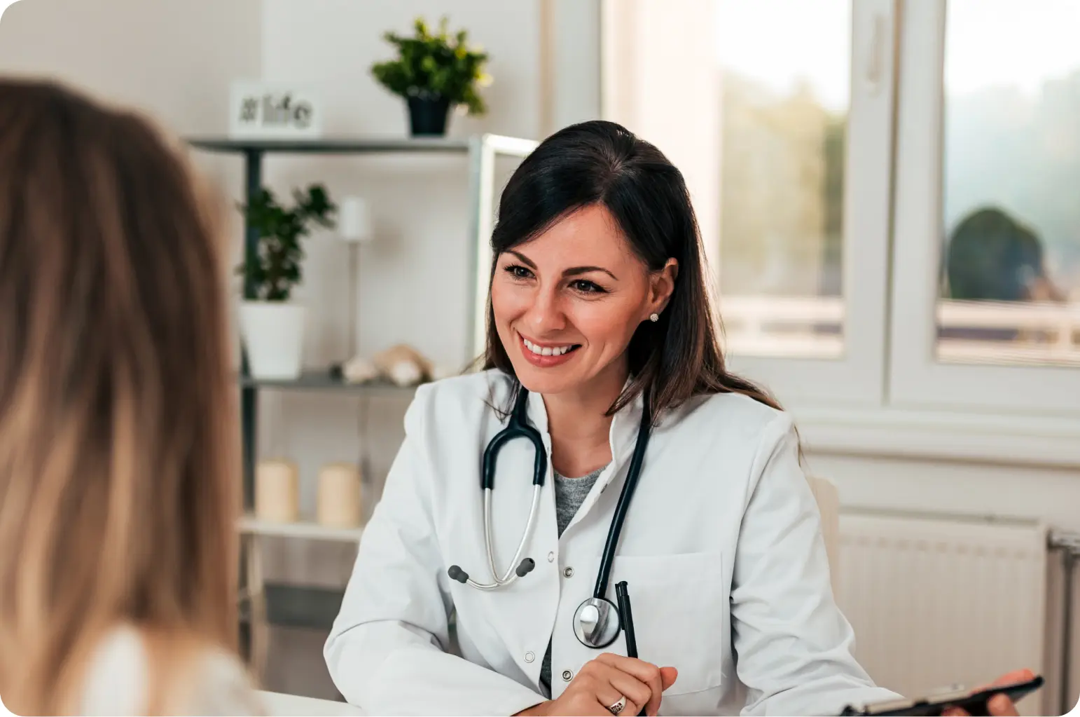 medica-sorrindo-para-paciente-em-consulta